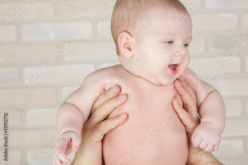 Photo: Smiling baby in the arms of his father. Smiling baby in the arms of his father.