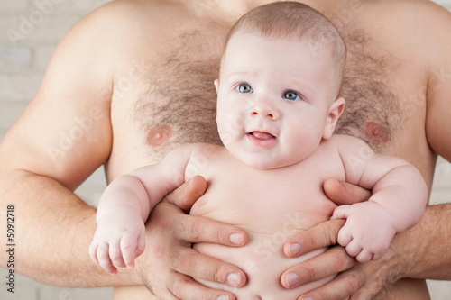 Photo: Happy baby on the strong hands of his father Happy baby on the strong hands of his father