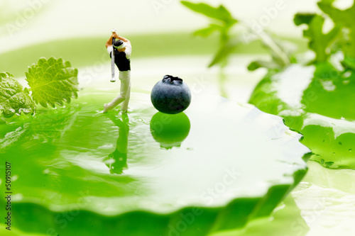 Photo: Miniature Figures playing golf on fruits Miniature Figures playing golf on fruits