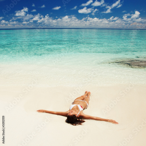 Photo: Cute woman relaxing on the tropical beach Cute woman relaxing on the tropical beach