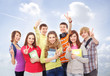Group of smiling teenagers staying together and looking at camer