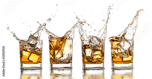 Photo: Whiskey glasses with splash, isolated on white background Whiskey glasses with splash, isolated on white background
