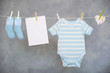 Blue baby goods and blank note hanging on the clothesline