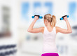 Photo: Young pretty woman holding weights and doing body training Young pretty woman holding weights and doing body training