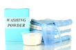 Box of washing powder with blue measuring cup and towels,