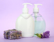 Liquid and hand-made soaps on purple background
