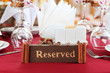 Reserved sign on restaurant table with empty dishes and glasses