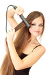 Woman doing hairstyle with hair straightener, isolated on white