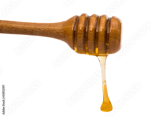 Photo: Honey dripping from a wooden honey dipper Honey dripping from a wooden honey dipper