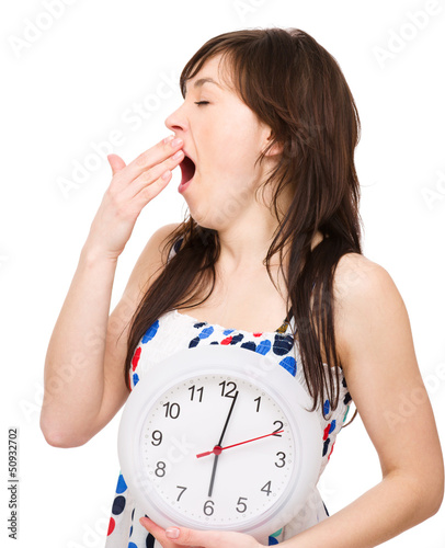 Photo: Young woman is holding big clock Young woman is holding big clock