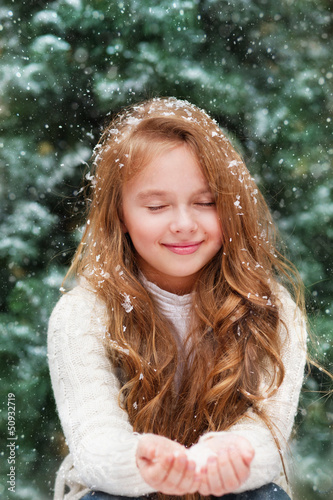 Photo: Beautiful liitle girl catches snowflakes Beautiful liitle girl catches snowflakes