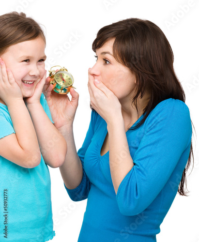 Photo: Little girl and her mother are anxious about time Little girl and her mother are anxious about time