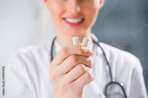 Photo: Female medical doctor - dentist - showing chewing gum. Dental ca Female medical doctor - dentist - showing chewing gum. Dental ca