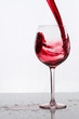 Ein Glas Rotwein eingiessen