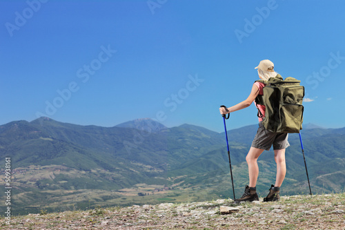 Photo: Woman with backpacki hiking a mountain Woman with backpacki hiking a mountain