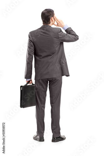 Photo: Full length portrait of a businessman thinking, shot from behind Full length portrait of a businessman thinking, shot from behind