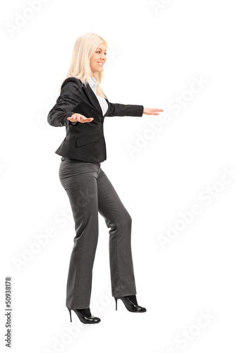 Photo: Full length portrait of a businesswoman trying to keep balance Full length portrait of a businesswoman trying to keep balance