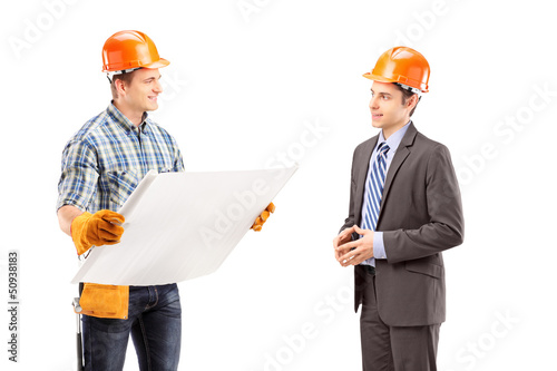 Photo: Male engineer holding a blueprint and having a conversation with Male engineer holding a blueprint and having a conversation with