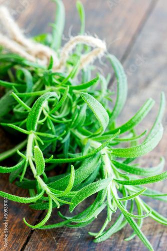 Photo: Fresh rosemary on a wooden board close up Fresh rosemary on a wooden board close up