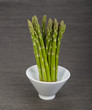 Asparagus in bowl on a black background