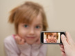 Man's hand making photo of a little girl with a mobile phone.