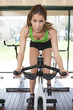 A young woman riding an exercise bike