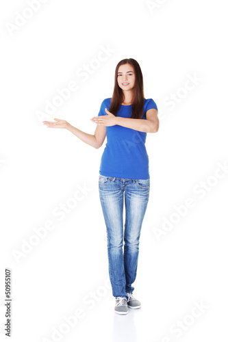 Photo: Excited young woman pointing on copy space Excited young woman pointing on copy space
