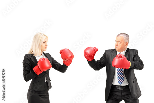 Photo: Businesswoman and businessman with boxing gloves having a fight Businesswoman and businessman with boxing gloves having a fight