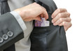 Putting banknotes in a jacket pocket