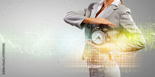 Photo: Business woman holding alarmclock Business woman holding alarmclock