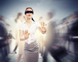 Businesswoman in blindfold among group of people