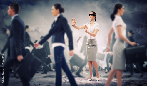 Photo: Businesswoman in blindfold among group of people Businesswoman in blindfold among group of people