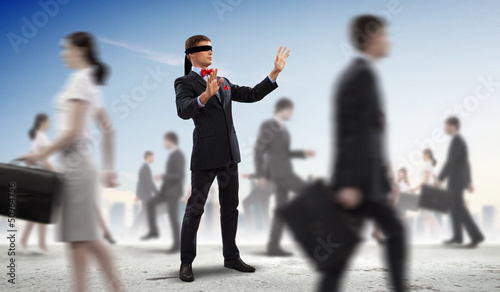 Photo: Businessman in blindfold among group of people Businessman in blindfold among group of people