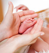 mother hands holding small baby's feet