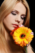 The beautiful woman with a Gerbera flower on black background