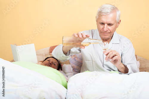 Photo: Seniors man with alcohol in bed Seniors man with alcohol in bed