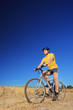 Photo: A young male with yellow shirt and helmet riding a mountain bike A young male with yellow shirt and helmet riding a mountain bike