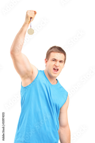 Photo: Young euphoric sportsman holding a gold medal Young euphoric sportsman holding a gold medal