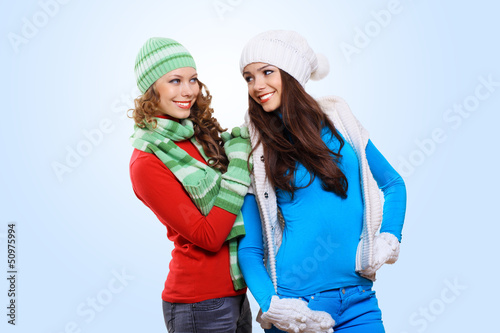 Photo: Two girls in winter hats and scarfs Two girls in winter hats and scarfs