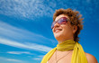 Photo: Smiling woman in sunglasses and yellow scarf admiring sea views Smiling woman in sunglasses and yellow scarf admiring sea views