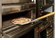 Putting pizza in oven
