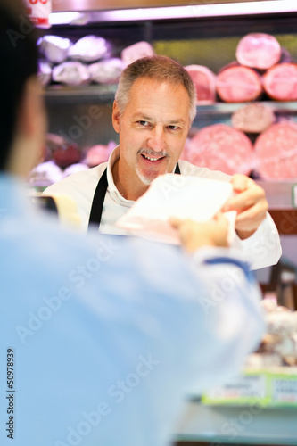 Photo: Shopkeeper serving a customer in a grocery store Shopkeeper serving a customer in a grocery store