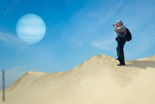 Photo: Tourist on a desolate planet taking photograph of its satellite Tourist on a desolate planet taking photograph of its satellite