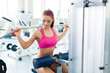 fitness model works out on training apparatus in fitness center