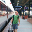 Photo: Just arrived: handsome young man walking along a platform Just arrived: handsome young man walking along a platform