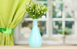Decorative flowers in vase on windowsill