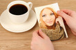 Photo in hands and cup of coffee on wooden table