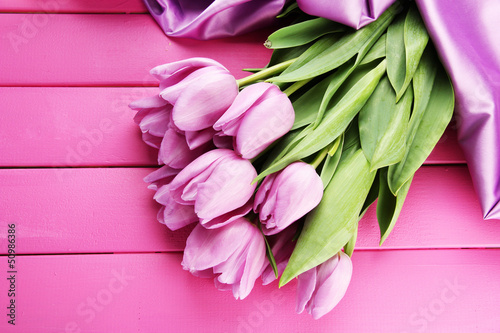 Photo: Beautiful bouquet of purple tulips on pink wooden background Beautiful bouquet of purple tulips on pink wooden background