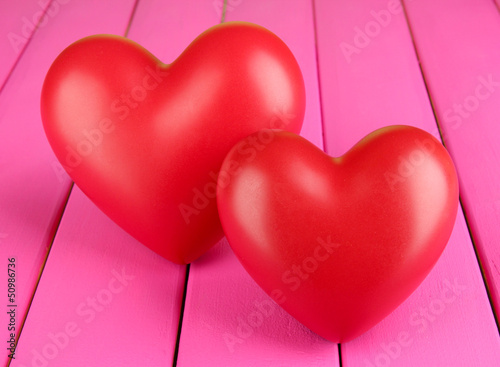 Photo: Decorative red hearts on color wooden background Decorative red hearts on color wooden background