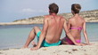 Young couple sitting on the beach, super slow motion